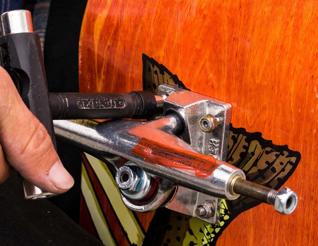 Truck de skate sendo instalado durante a montagem de um skate